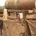 One of the few luxuries at Bu Dop. Unidentified cannoneer enjoying a hot shower. The shower only had 3 sides and sometimes the wind would blow through the  unprotected side and it chilled you till certain body parts shrank considerably.  Bu Dop latter half 1970.
